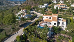 A large, modern villa with a swimming pool, surrounded by lush greenery and a winding road. - Villa Vinalopo La Sella (Pedreguer)