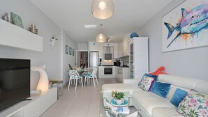 A modern living room with a TV, sofa, and dining area. - Apartment Octopus Moraira (Moraira)