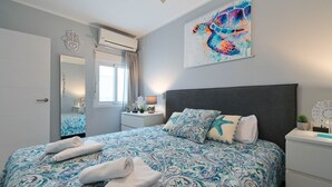 A bedroom with a large bed, a nightstand, a mirror, and a wall art piece. - Apartment Octopus Moraira (Moraira)