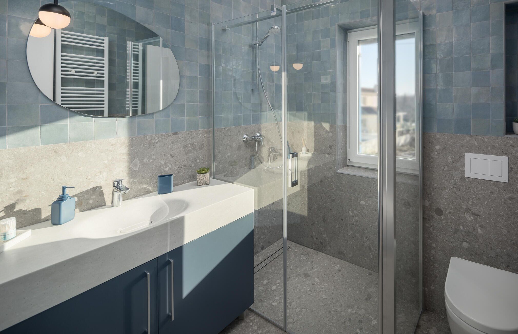 Une salle de bain moderne dotée d’une douche à parois de verre, d’un grand miroir et d’un meuble-lavabo à deux vasques.
