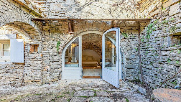 A stone-walled room with an open doorway leading to a bed. - Nice home in LE ROUET with house a panoramic view (LE ROUET)