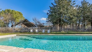 A clear swimming pool with a wooden deck in the foreground, surrounded by a wooden fence and trees. - Nice home in LE ROUET with house a panoramic view (LE ROUET)