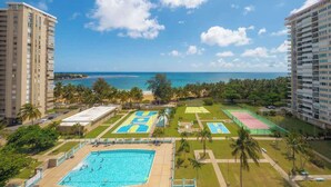 A resort with a large swimming pool, tennis courts, and a view of the ocean. - Cozy BEACH FRONT 1BR w/Pool & PK @Luquillo Beach (Luquillo)