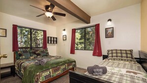 A bedroom with two beds, a ceiling fan, and windows with red curtains. - Inside Yosemite Park 3BR Sleeps 8 Game Loft (Yosemite Valley)