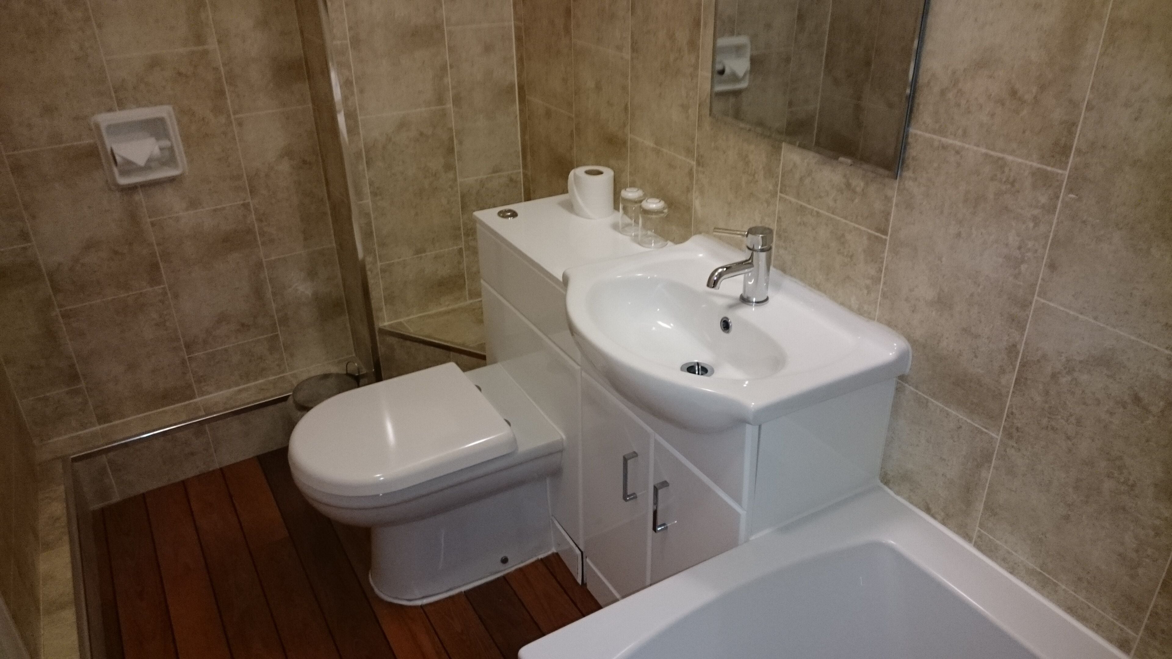 A bathroom with a toilet, sink, and bathtub.