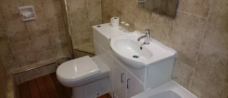 A bathroom with a toilet, sink, and bathtub.