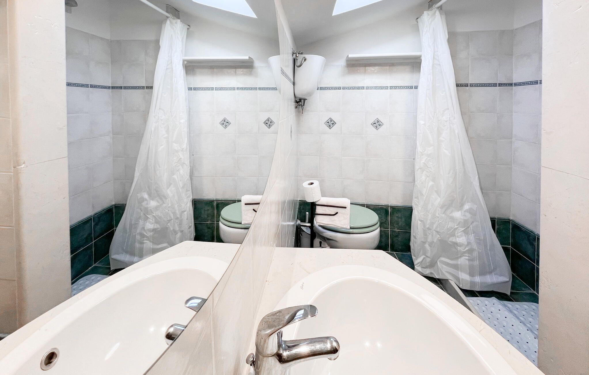 Ein Badezimmer mit zwei Waschbecken, einer Toilette und einer Duschkabine.