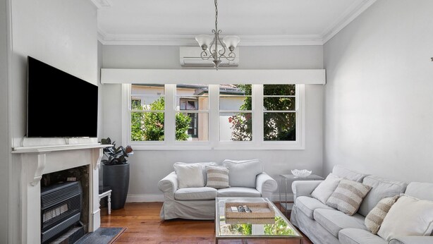 A living room with a fireplace, a sofa, a coffee table, and a TV. - Charming House in Woolwich (Woolwich)