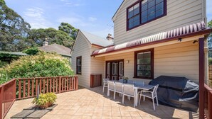 A house with a patio, a barbecue area, and a dining table with chairs. - Charming House in Woolwich (Woolwich)