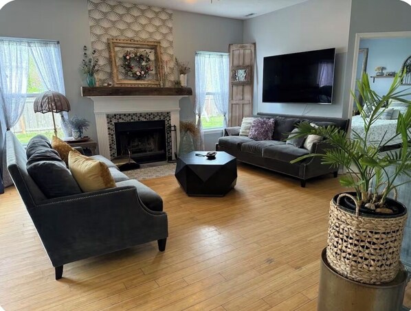 Un salon avec une cheminée, un canapé, une table basse et un téléviseur.