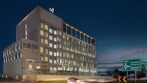 Un hôtel moderne, avec de nombreux étages et de grandes fenêtres.
