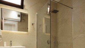 Une salle de bain moderne avec une douche à parois de verre, un lavabo blanc et un porte-serviettes.
