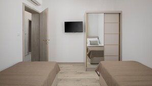 Camera da letto con due letti, una TV e un armadio.