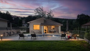 Una casa moderna con patio, area relax esterna e piscina.
