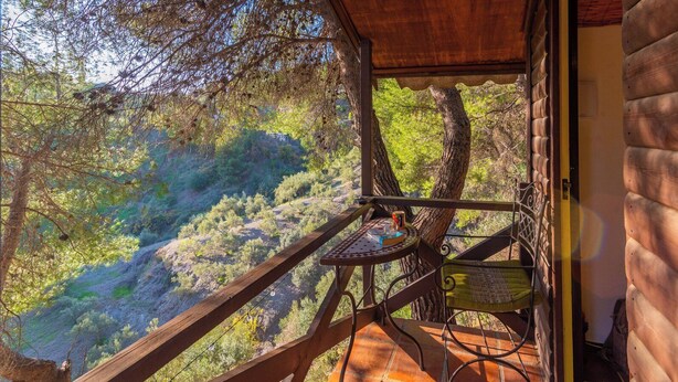 A wooden deck with a table and chairs overlooking a mountainous landscape. - Casa Surrender Cómpeta by Ruralidays (Málaga)