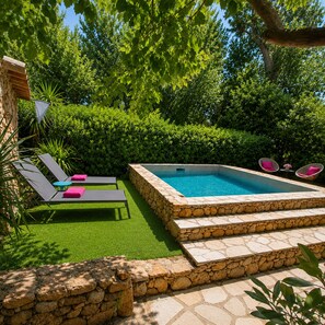 A swimming pool with stone steps, surrounded by a stone wall, and a grassy area with lounge chairs. - Salvacintoggio Bergerie 2 persons Private swimming pool (Porto-Vecchio)