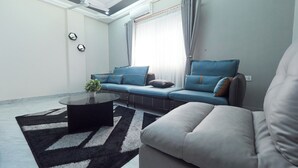 A modern living room with a sectional sofa, a round coffee table, and a patterned rug.