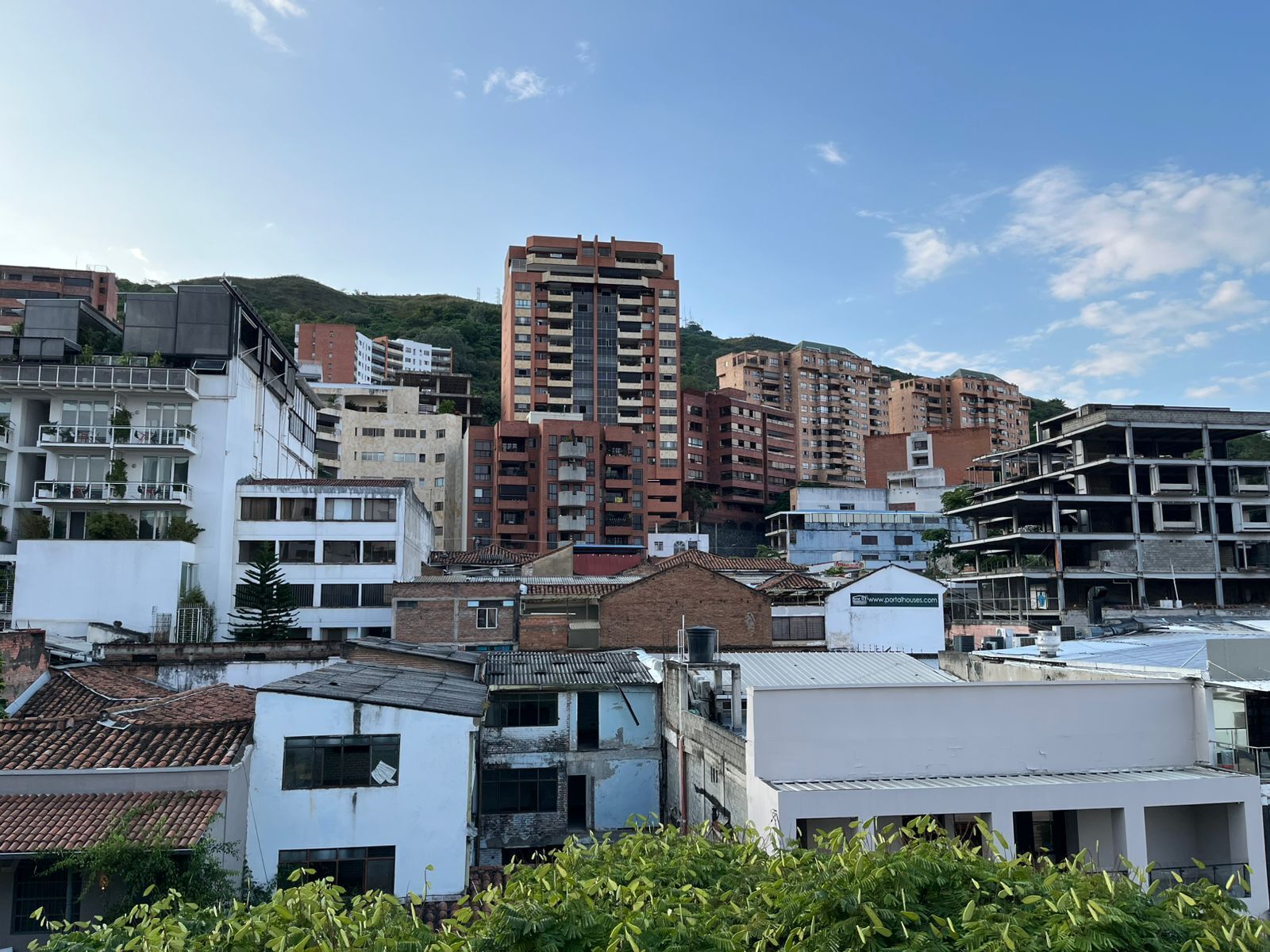 Un edificio de varios pisos con un diseño arquitectónico moderno, que cuenta con balcones y ventanas amplias.