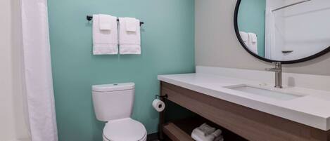 A bathroom with a toilet, a sink, and a mirror.