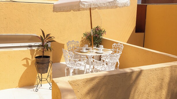 A small outdoor seating area with a white umbrella, a table, chairs, and a potted plant. - Casa 25 Lizette Luxury for 6-7 px with Pool Cancun! (Cancún)
