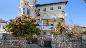 A multi-story building with balconies, a stone wall, and a clear sky. - Pet friendly apartment in Opatija with WiFi (Opatija)