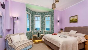 A bedroom with a bed, a chair, a desk, a lamp, and a view of the sea. - Pet friendly apartment in Opatija with WiFi (Opatija)