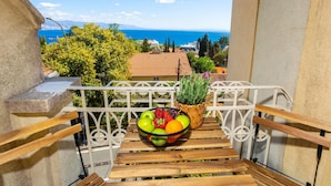 A balcony with a view of the sea, a bowl of fruit, and a potted plant. - Pet friendly apartment in Opatija with WiFi (Opatija)