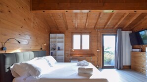 Acogedora habitación tipo cabaña de madera con cama, escritorio y televisor.
