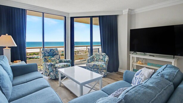 A hotel room with a balcony, a TV, and a sofa. -  Discount option!! Beautiful views! 3BR/3BA Oceanfront condo Ocean Creek Resort! (Myrtle Beach)