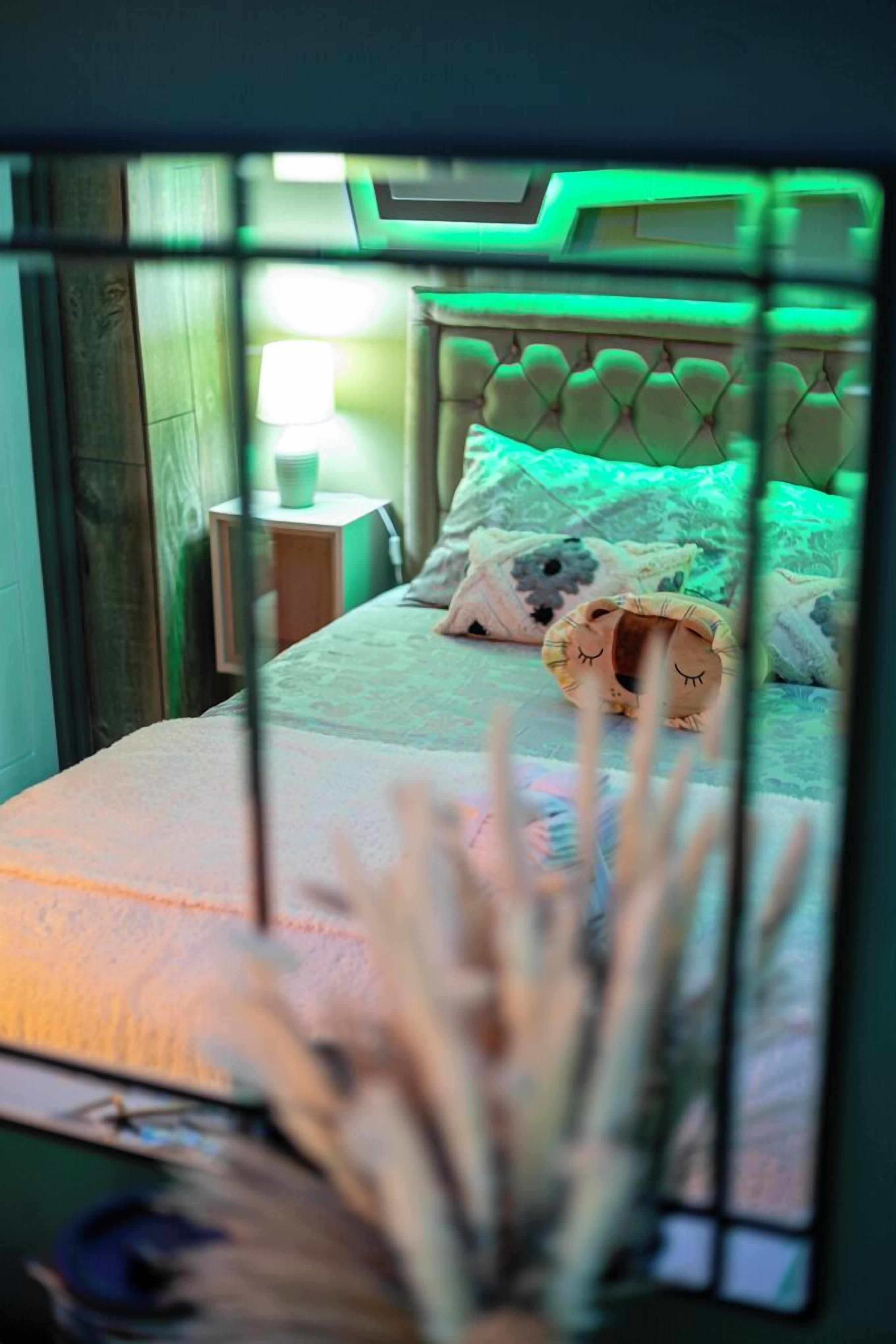 A bedroom with a bed, pillows, and a nightstand.