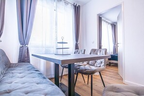 Une pièce moderne et bien éclairée, avec un canapé, une table à manger et des chaises.