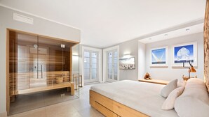 Et moderne soveværelse med en stor seng, et walk-in closet og havudsigt.