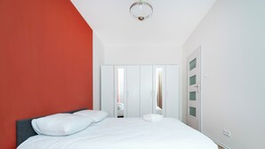 Une chambre à coucher avec un lit, une armoire et un miroir.