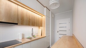 A modern kitchen with wooden cabinets, a stainless steel sink, and a wooden countertop. - Racjonalizacji Stylish Apartment (Warszawa)