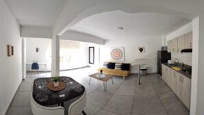 A spacious living area with a dining table, sofa, and kitchen. - Ingenio Park 83 - Apartaestudios (Cali)