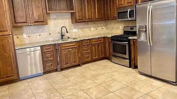 A kitchen with wooden cabinets, stainless steel appliances, and a tiled floor. - Desert Voyage | Pool | Near ASU + Old Town Scottsdale (Tempe)