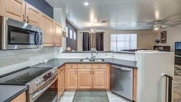 A compact kitchen with wooden cabinets, a built-in oven, a microwave, and a dishwasher.