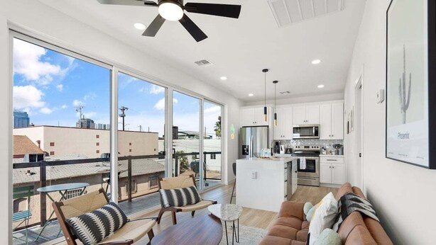 Eine moderne Wohnung mit Balkon, einer Küche und einem Wohnbereich.