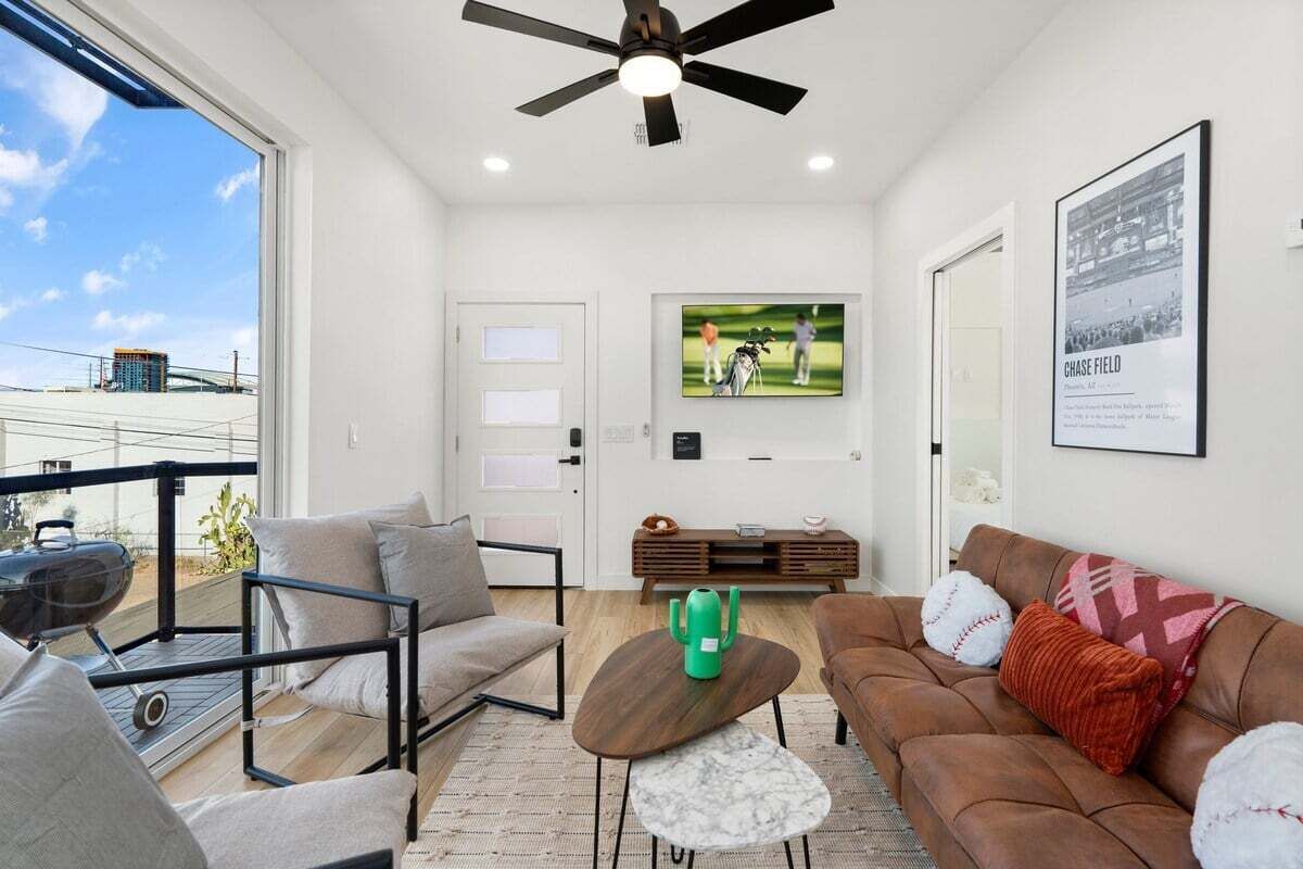A modern living room with a sofa, a coffee table, and a television mounted on the wall.