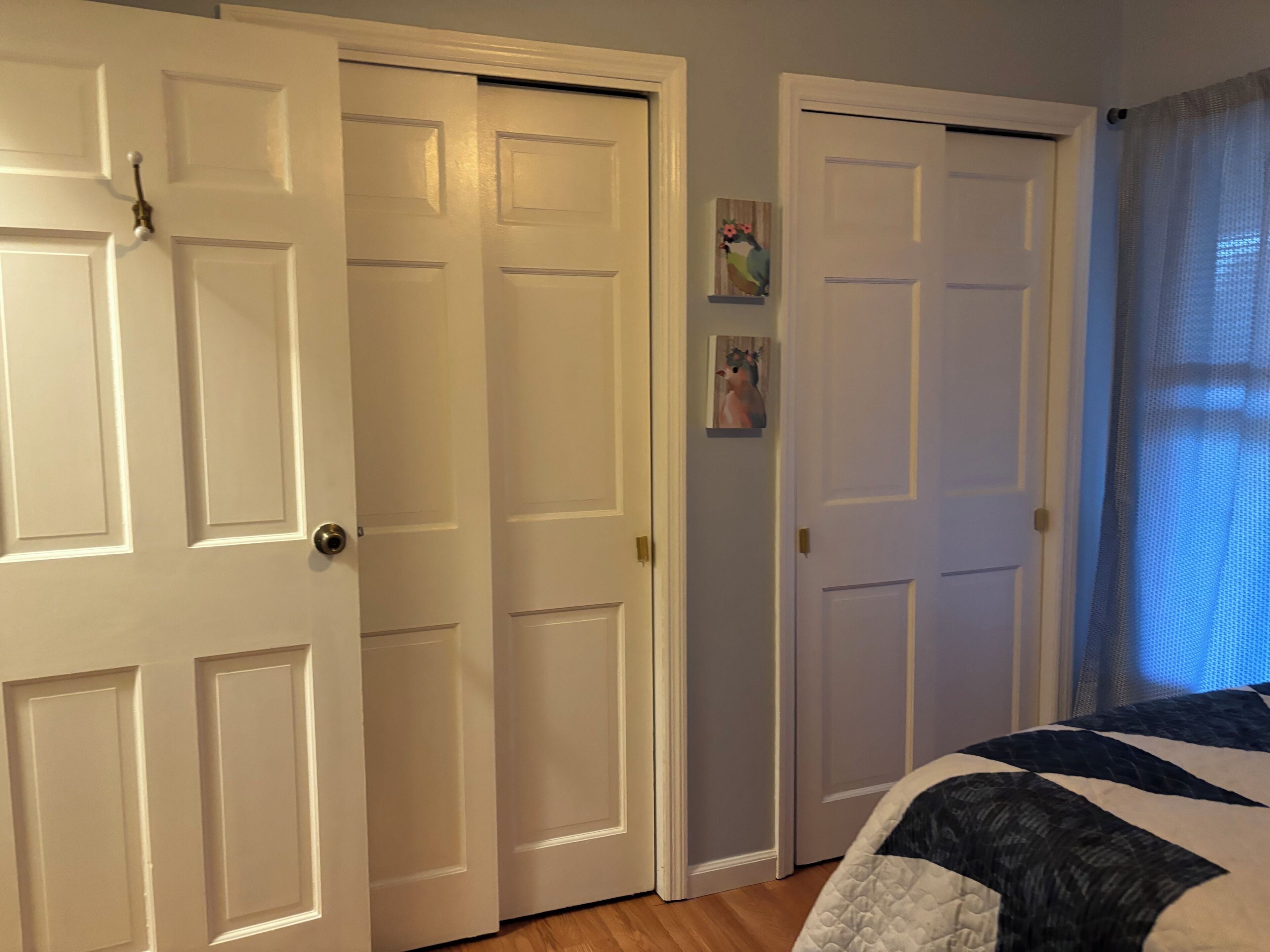 Une chambre à coucher avec un lit, une porte et une fenêtre avec des rideaux.