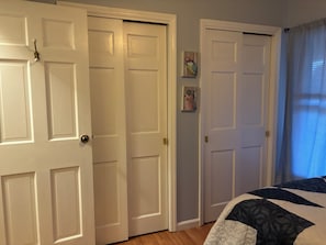 Una camera da letto con un letto, una porta e una finestra con tende.