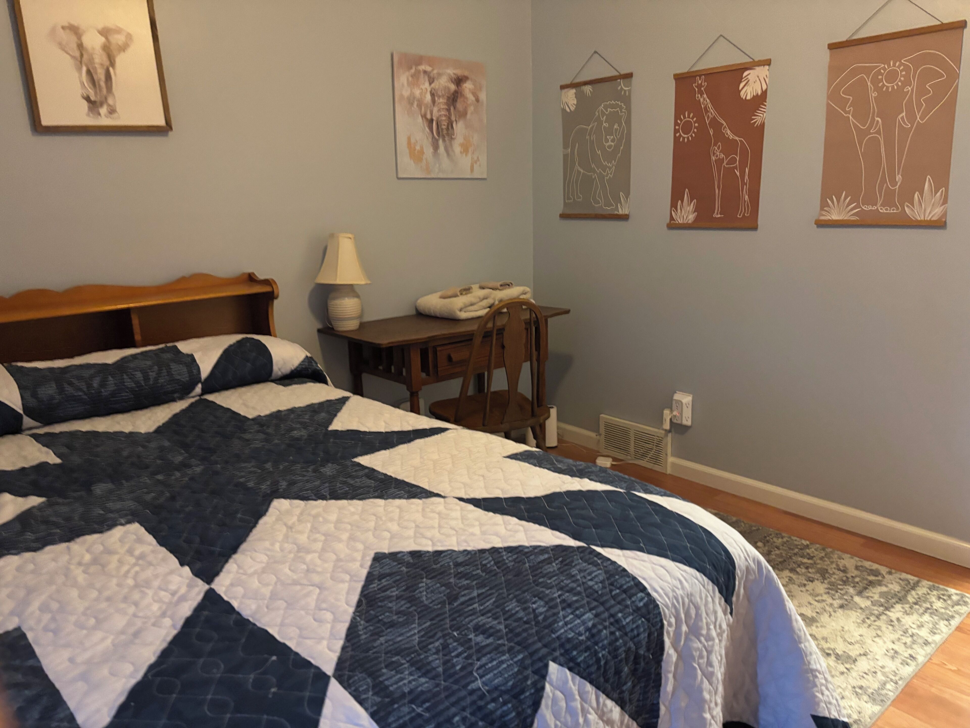 Un dormitorio con cama, escritorio y decoración en la pared.