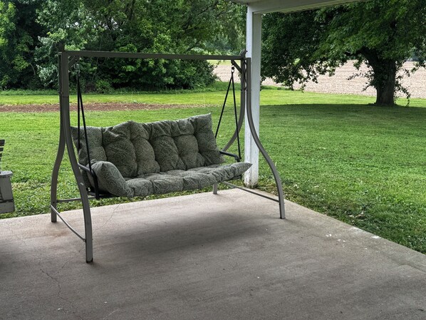 A concrete patio with a swing chair.