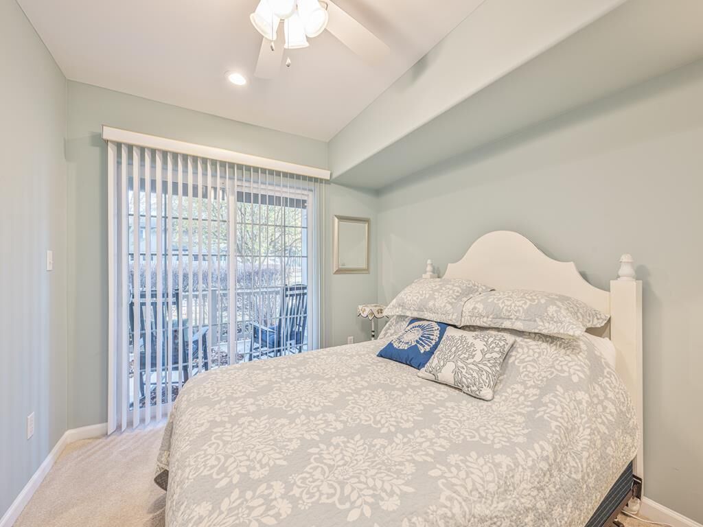 Un dormitorio con cama, ventana con persianas y vistas al exterior.