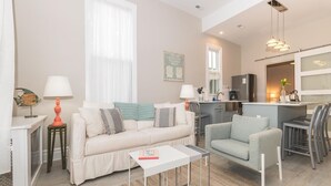 Een moderne woonkamer met een bank, een salontafel en een eethoek met stoelen.