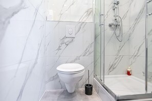 A bathroom with a toilet, a bidet, and a shower area.