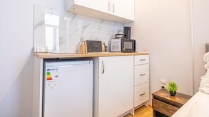 A compact kitchenette with a refrigerator, microwave, and coffee maker on a wooden countertop. - Cozy & Quiet Studio in Vienna’s 12th District (Vienna)