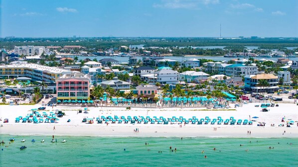 A coastal resort with beachfront accommodations, a marina, and a sandy beach.