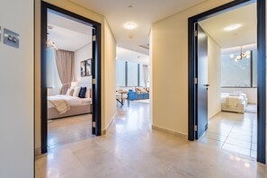 Ein moderner Hotelkorridor mit einem Bett, einem Schreibtisch und einer Couch im Hintergrund.