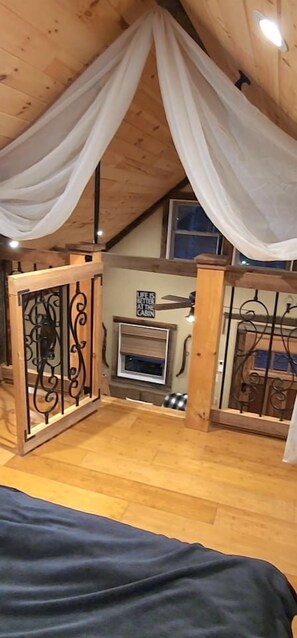 A tent-like room with a fireplace, curtains, and a bed. - Cozy Cabin w/Loft Bedroom * Firepit * Creek Access (Dahlonega)